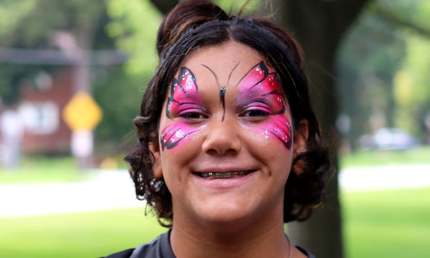 SSSRA participant smiling, wearing face paint of butterfly art
