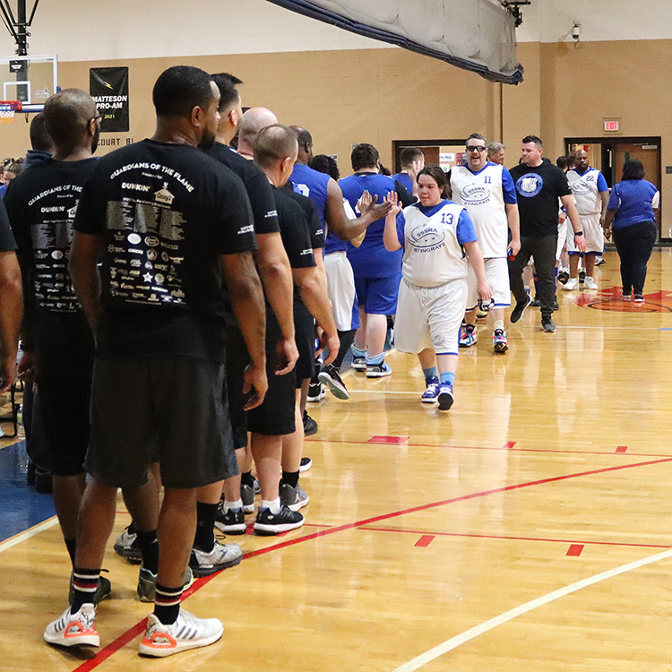 Stingrays athletes and players from the police departments line up to give each other high fives to celebrate the game.