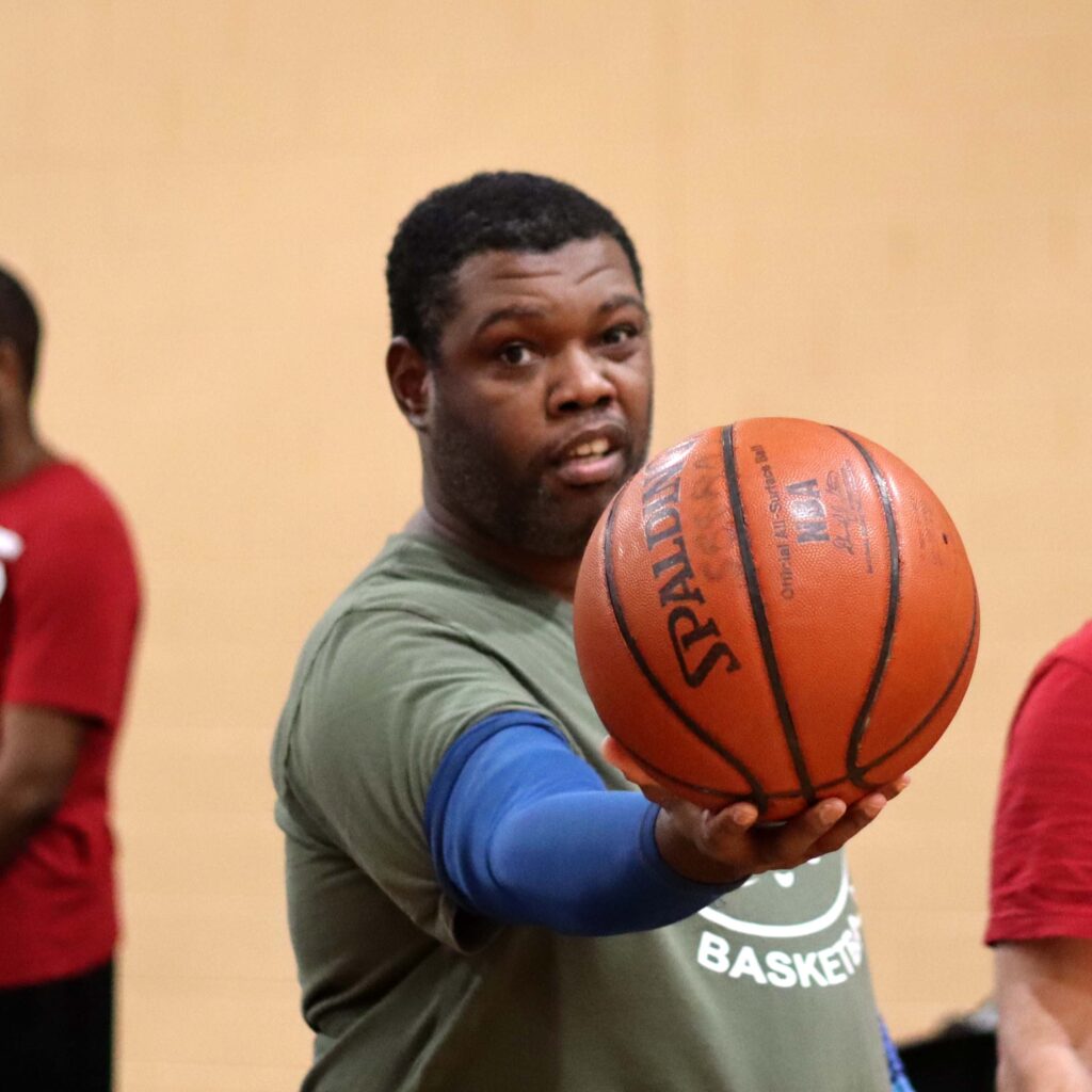 Stingrays athlete holds basketball up to the camera.