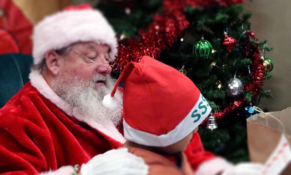 Santa reading letter with young participant