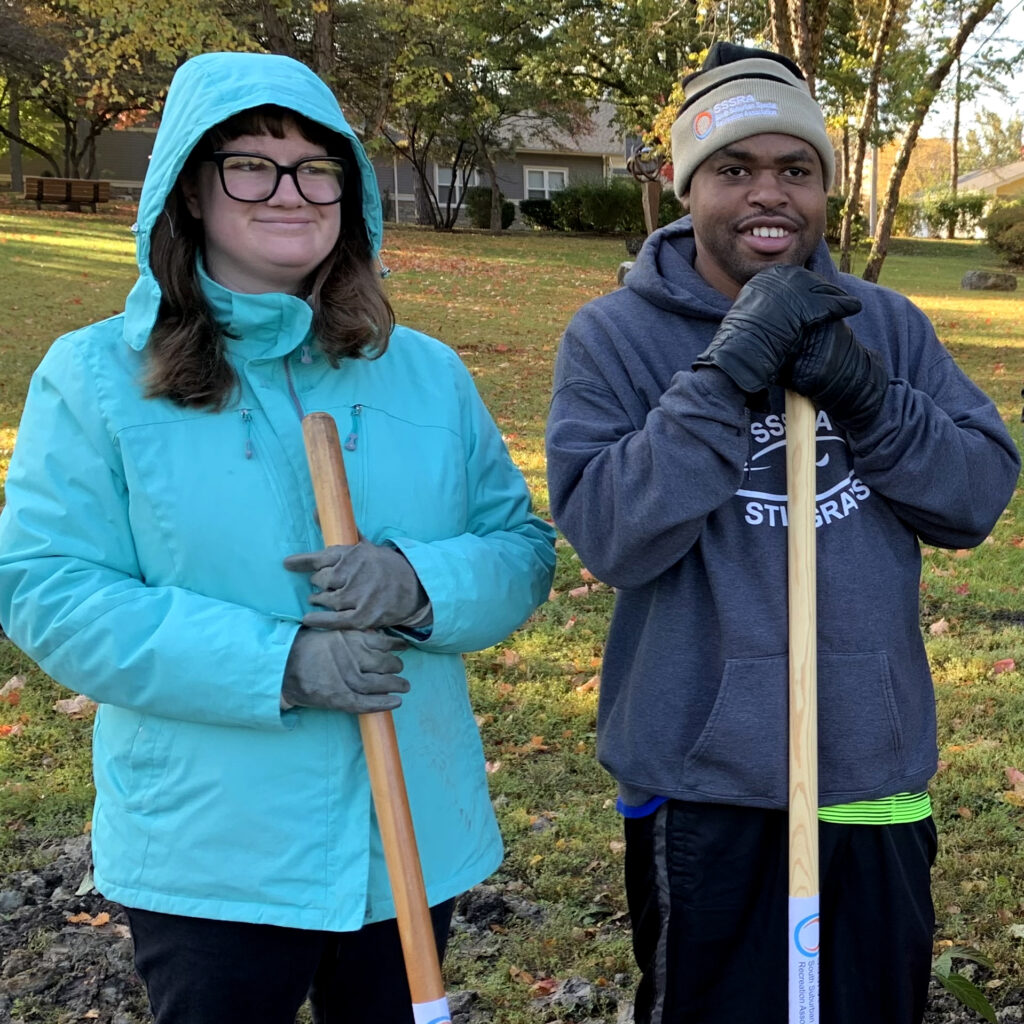 Two volunteers at Plant the gem pose with their shovels